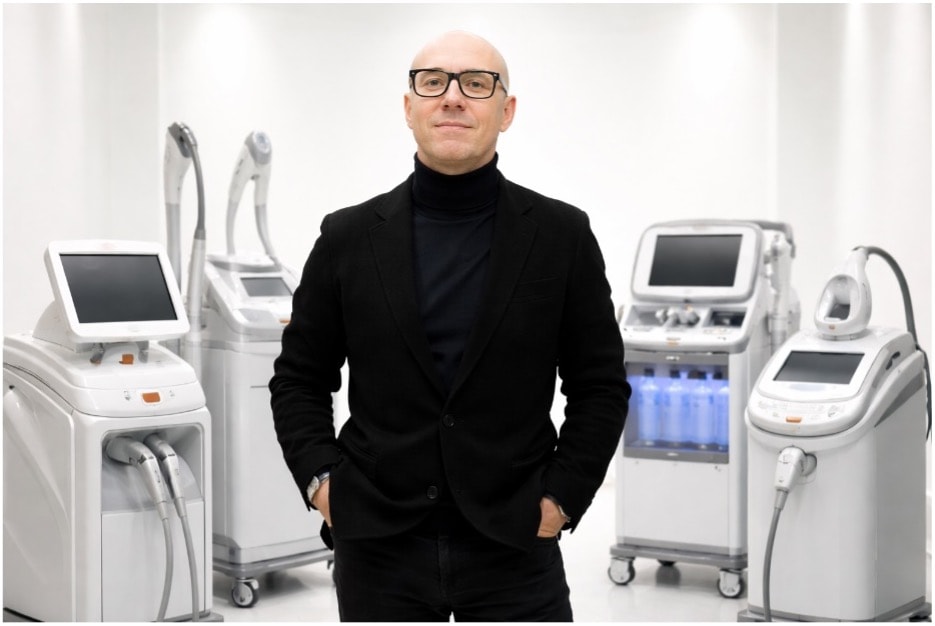 Nikita, Experte für Kosmetikgeräte, umgeben von professionellen Laser- und Kosmetikgeräten